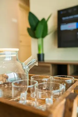 a group of glasses sitting on a table with a pitcher at Stylish River-View Apartment In Ipoh in Ipoh
