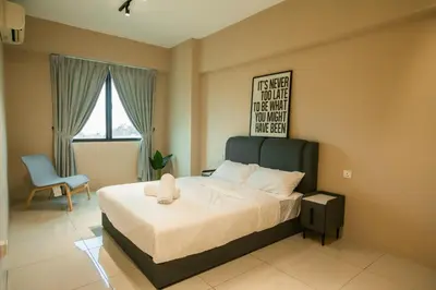 a bedroom with a bed and a chair and a window at Stylish River-View Apartment In Ipoh in Ipoh