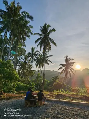 a group of people sitting around a table watching the sunset at Homestay Tepi Sungai Perak in Kuala Kangsar