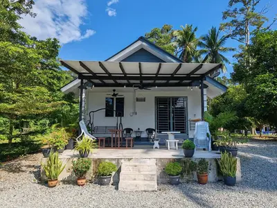 a small white house with a pergola at Homestay Tepi Sungai Perak in Kuala Kangsar