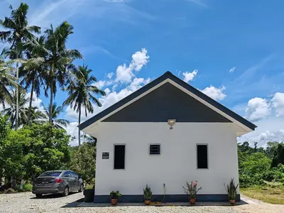 a white house with a black roof at Homestay Tepi Sungai Perak in Kuala Kangsar