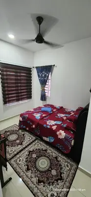 a bedroom with a bed and a rug on the floor at D'Haty Homestay in Padang Serai