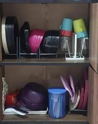 a wooden shelf with different colored plates and cups at D'Haty Homestay in Padang Serai