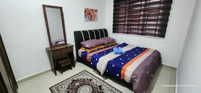 a bedroom with a bed and a mirror at D'Haty Homestay in Padang Serai