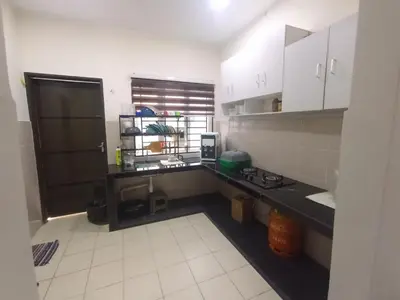 a kitchen with a black counter and white cabinets at A&H Homestay Teluk Senangin in Segari