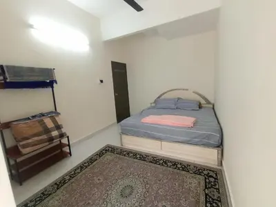 a bedroom with a bed and a rug at A&H Homestay Teluk Senangin in Segari