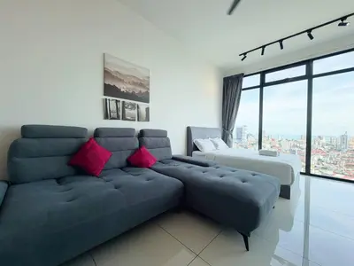a living room with a blue couch with pink pillows at Beacon Executive Suite by Uptrend Home Management in George Town