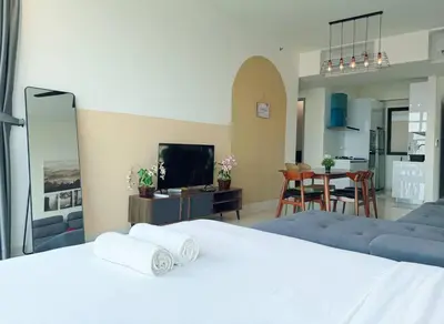 a bedroom with a bed and a living room at Beacon Executive Suite by Uptrend Home Management in George Town