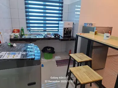 a kitchen with a sink and a counter with two stools at 132-A, JHC Homestay Puncak in Kampung Bota Kiri