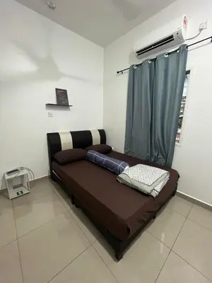 a bed in a room with a blue curtain at Manong Kuala Kangsar Homestay Chegu Wok in Manong
