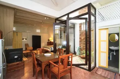 a dining room with a table and a living room at Shophouse Studio in George Town