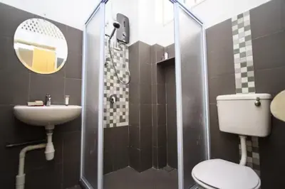 a bathroom with a toilet and a sink and a mirror at Shophouse Studio in George Town