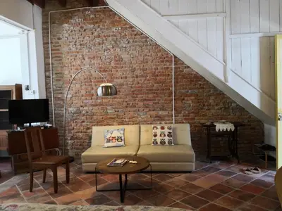 a living room with a couch and a brick wall at Shophouse Studio in George Town