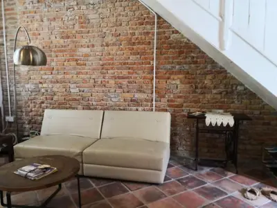 a living room with a couch and a brick wall at Shophouse Studio in George Town