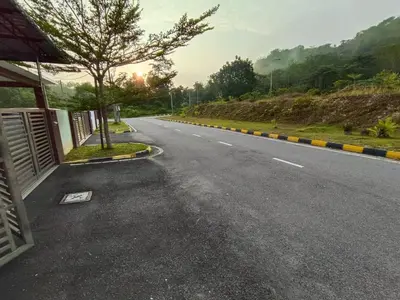 an empty road with a tree on the side of the road at Homestay Teacher,Perak, Gerikmist in Gerik