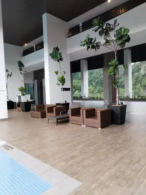 a large empty room with chairs and potted plants at Sunway Onsen Suites beautiful view in Kampong Batu Lapan