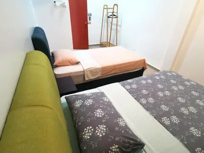 a room with two beds and a green couch at Calm in Kuala Kubu Bharu in Kuala Kubu Baharu