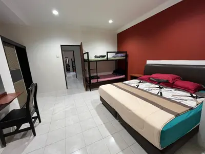 a bedroom with a bed and a red wall at Big Dreams Double Story House in Tanah Rata