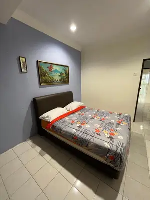 a bed in a bedroom with a blue wall at Big Dreams Double Story House in Tanah Rata
