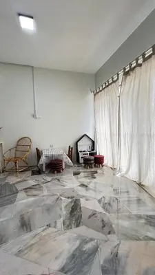 an empty living room with a marble floor and curtains at 515 Nana’s Homes in Sekinchan in Sekincan