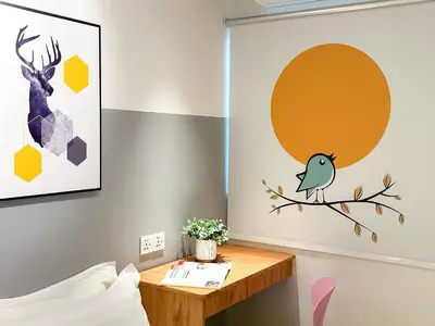 a bedroom with a table with a bird on a branch at Apple 1 Hotel Gurney in George Town