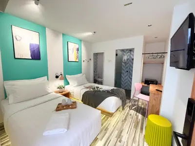 a hotel room with two beds and a tv at Apple 1 Hotel Gurney in George Town