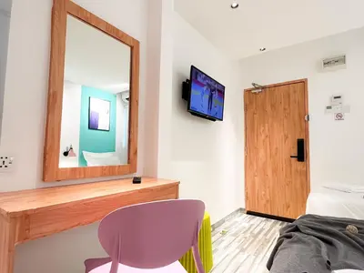 a bedroom with a mirror and a chair and a bed at Apple 1 Hotel Gurney in George Town