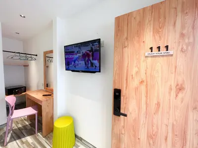 a room with a tv hanging on the wall at Apple 1 Hotel Gurney in George Town