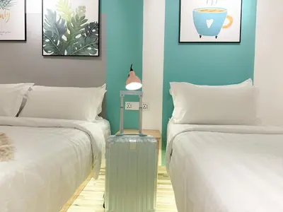 a room with two beds and a suitcase between them at Apple 1 Hotel Gurney in George Town