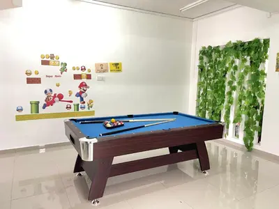a ping pong table in a room with a pool at HAPPY GATHER HOMESTAY in Ipoh
