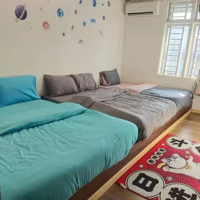 two beds sitting next to each other in a room at HAPPY GATHER HOMESTAY in Ipoh