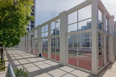 a building with large windows with buildings in the background at SQSu in Tanjong Tokong