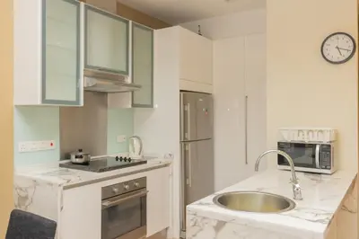 a white kitchen with a sink and a microwave at SQSu in Tanjong Tokong