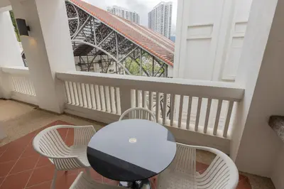 a table and chairs on a balcony with a bridge at SQSu in Tanjong Tokong