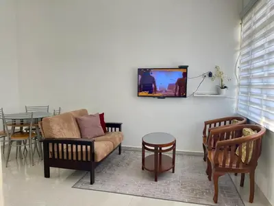 a living room with a couch and a tv on a wall at Rumah Kami Homestay in Butterworth