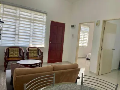 a living room with a couch and chairs and a table at Rumah Kami Homestay in Butterworth