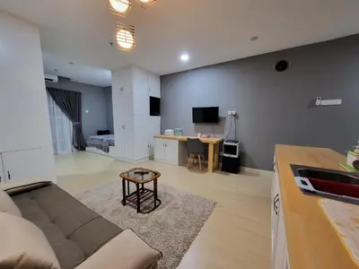 a living room with a couch and a table at NICE and COZY studio apartment with gym and pool. in Kampar