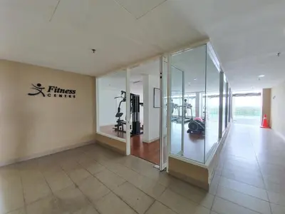 a fitness center with a gym with glass walls at NICE and COZY studio apartment with gym and pool. in Kampar