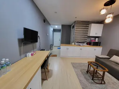 a living room and kitchen with a couch and a table at NICE and COZY studio apartment with gym and pool. in Kampar