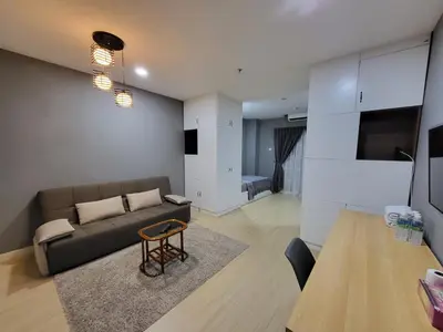 a living room with a couch and a table at NICE and COZY studio apartment with gym and pool. in Kampar