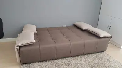 a brown bed with two pillows on it in a room at NICE and COZY studio apartment with gym and pool. in Kampar