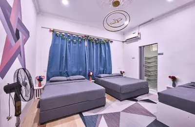 a room with two beds and a fan at Penang Dream Banglo Sleeps 28 in Tanjung Bungah