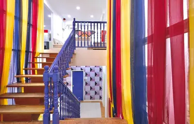 a hallway with colorful curtains and stairs in a house at Penang Dream Banglo Sleeps 28 in Tanjung Bungah