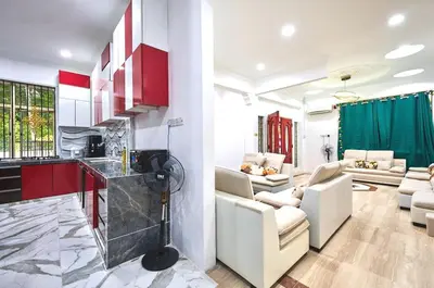 a kitchen and living room with red cabinets at Penang Dream Banglo Sleeps 28 in Tanjung Bungah