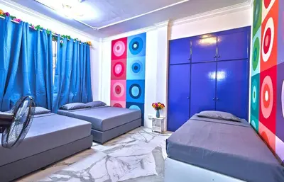 two beds in a room with blue and red curtains at Penang Dream Banglo Sleeps 40 in Tanjung Bungah