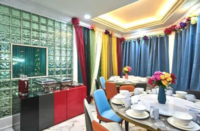 a dining room with tables and chairs and curtains at Penang Dream Banglo Sleeps 22 in Tanjung Bungah