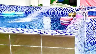a swimming pool with a water fountain in it at Penang Dream Banglo Sleeps 22 in Tanjung Bungah