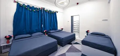 a bedroom with two beds and a blue curtain at Penang Dream Banglo Sleeps 22 in Tanjung Bungah