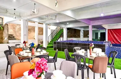 a restaurant with tables and chairs and a lawn at Penang Dream Banglo Sleeps 18 in Tanjung Bungah
