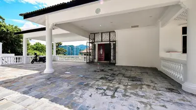 a white house with a porch and a patio at Penang Dream Banglo Sleeps 18 in Tanjung Bungah